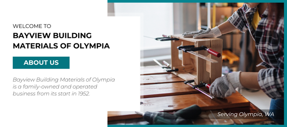 A person wearing gloves works with woodworking clamps on a wooden project. To the left, text reads 'Welcome to Bayview Building Materials of Olympia. About Us. Bayview Building Materials of Olympia is a family-owned and operated business from its start in 1952. Serving Olympia, WA.